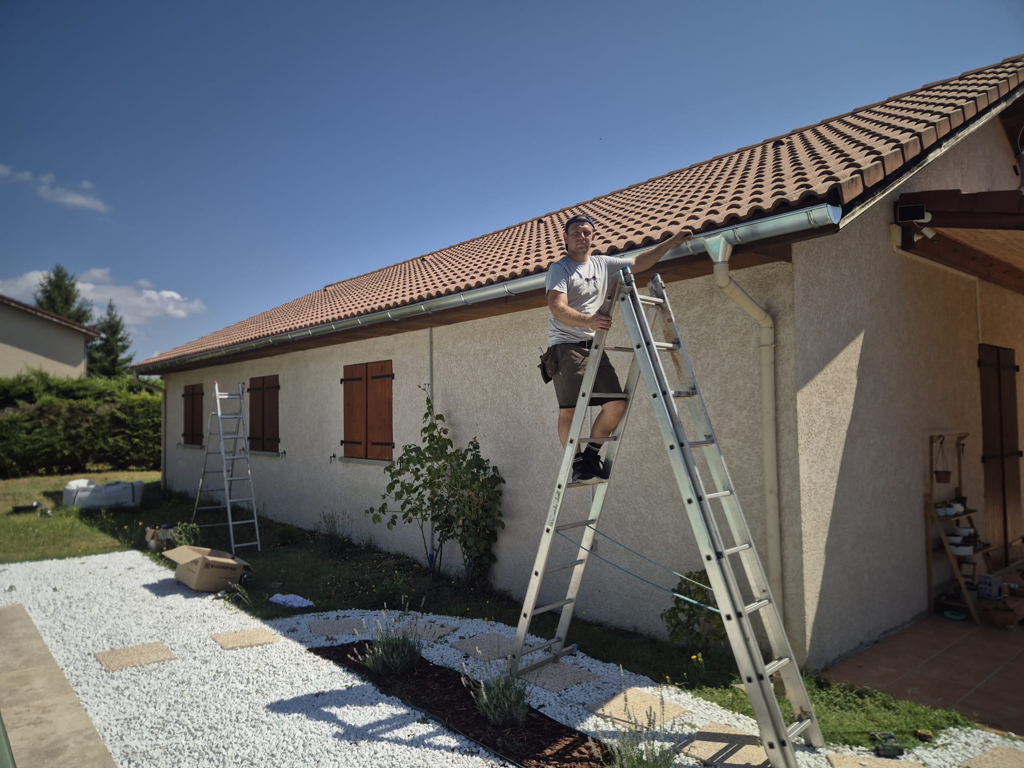 Couvreur KOCH TOITURE posant une gouttière en zinc sur une maison en Drôme
